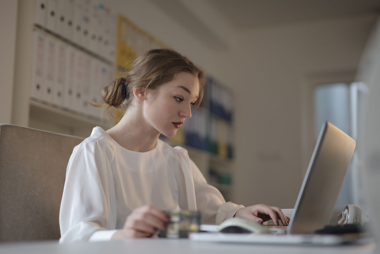 Young woman concentrating on her laptop at a desk in a modern office