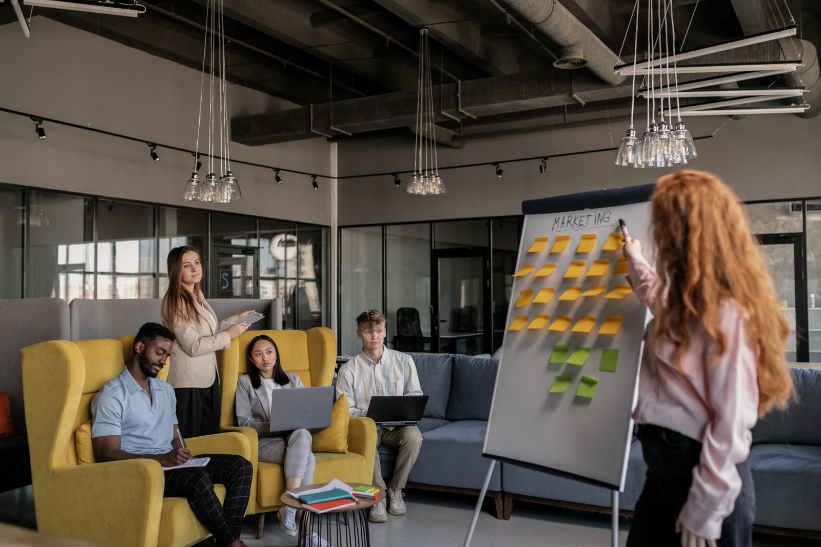 Team planning a marketing strategy on a whiteboard covered in sticky notes
