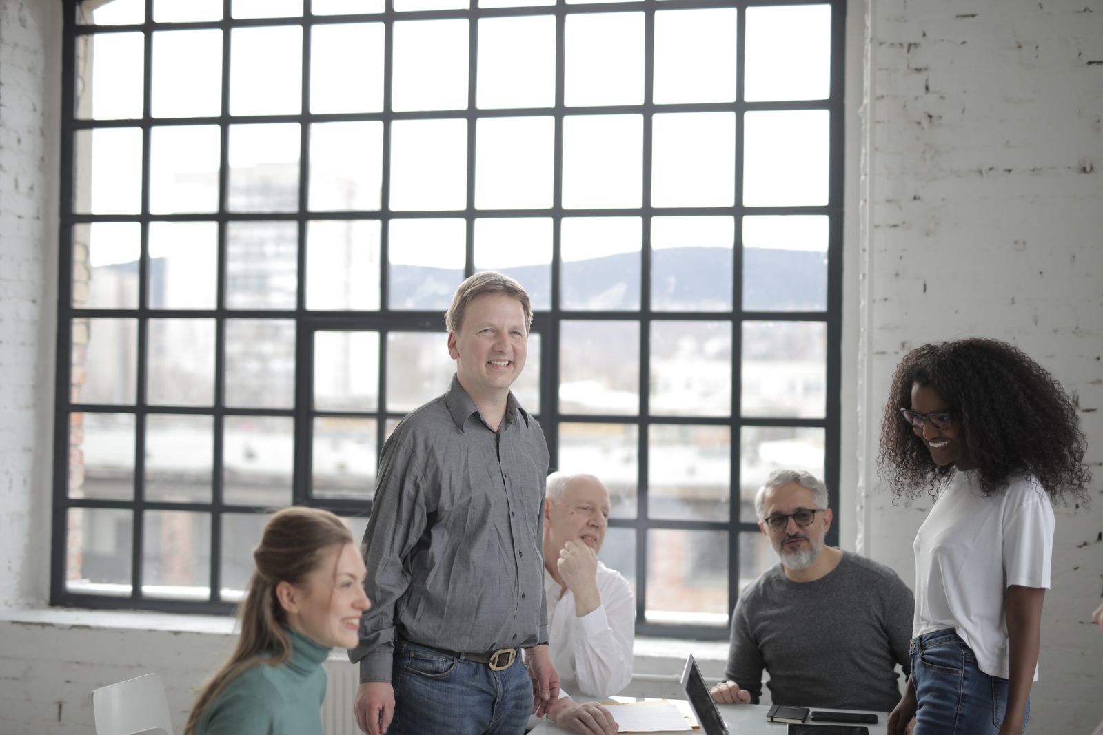 Colleagues of different ages laughing together around an office desk