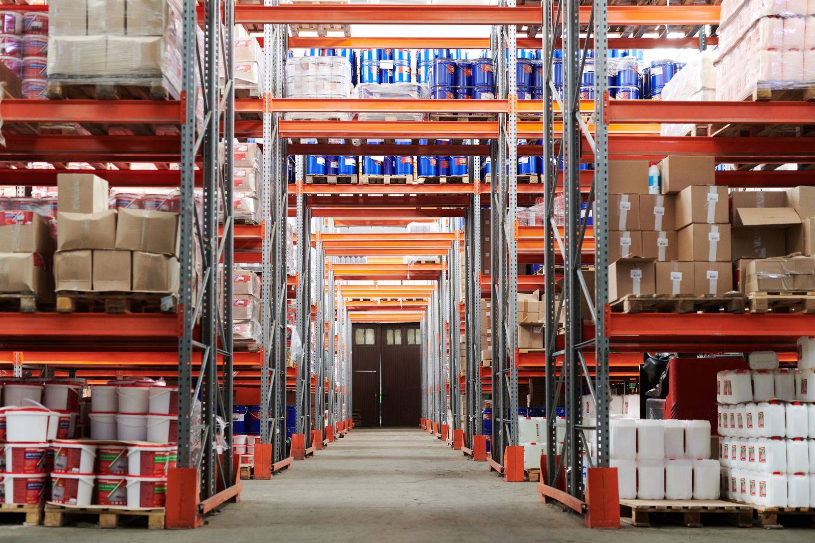Wide view of a warehouse with tall racking stocked with labelled boxes